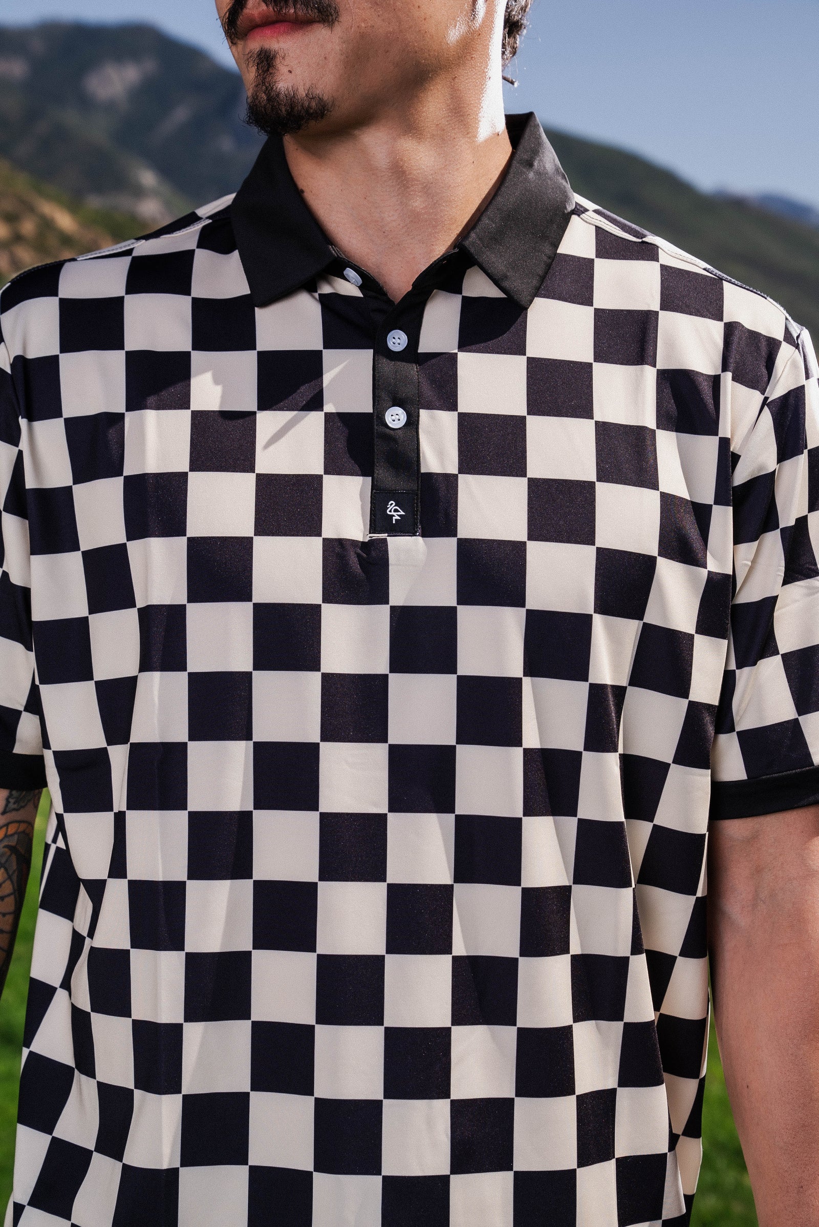 Men’s black-and-white checkerboard polo – retro-inspired, breathable, stretch-performance ready.