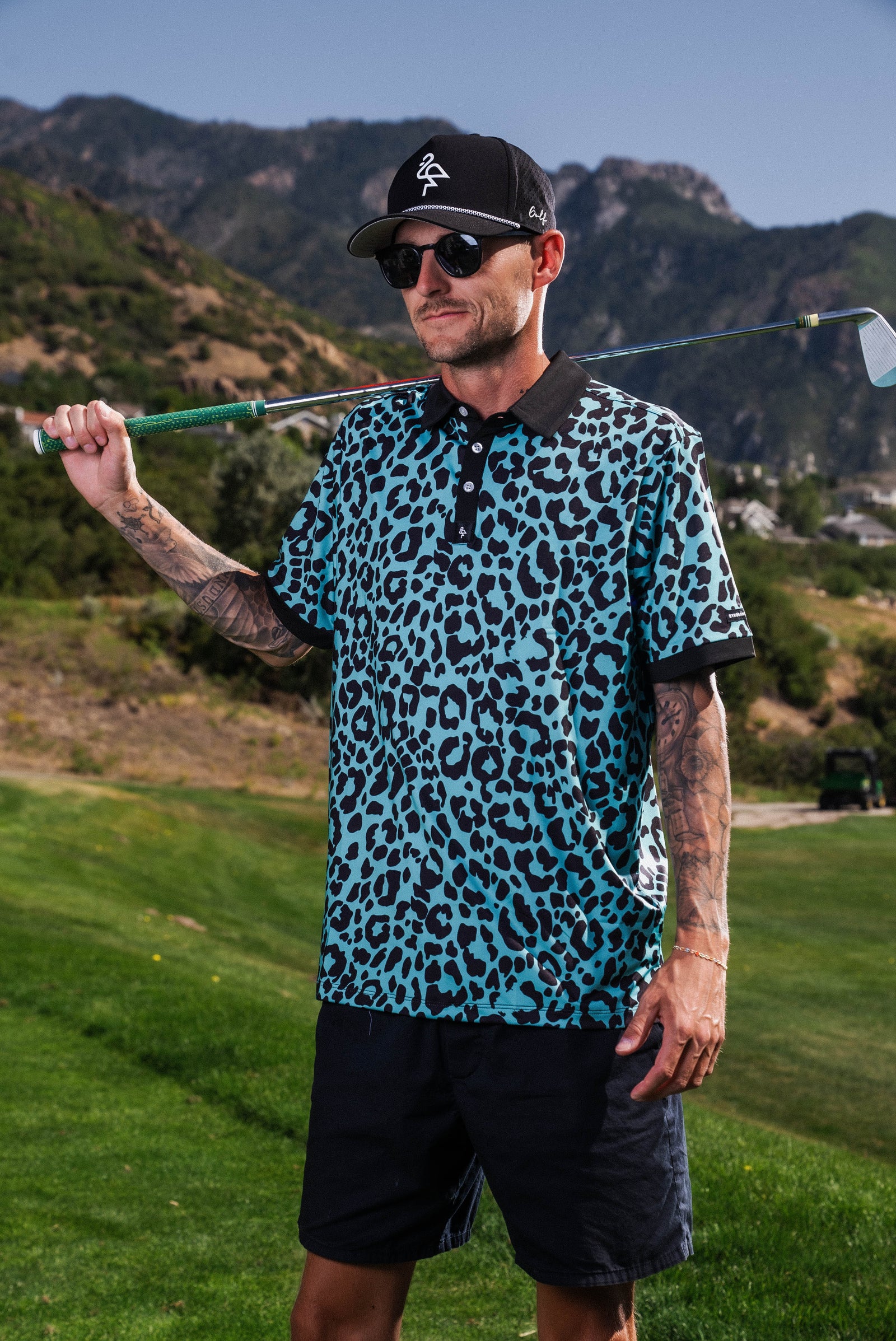 Men’s teal polo with tiger-stripe pattern – bold, breathable design with stretch, UPF 50+, and moisture-wicking performance.