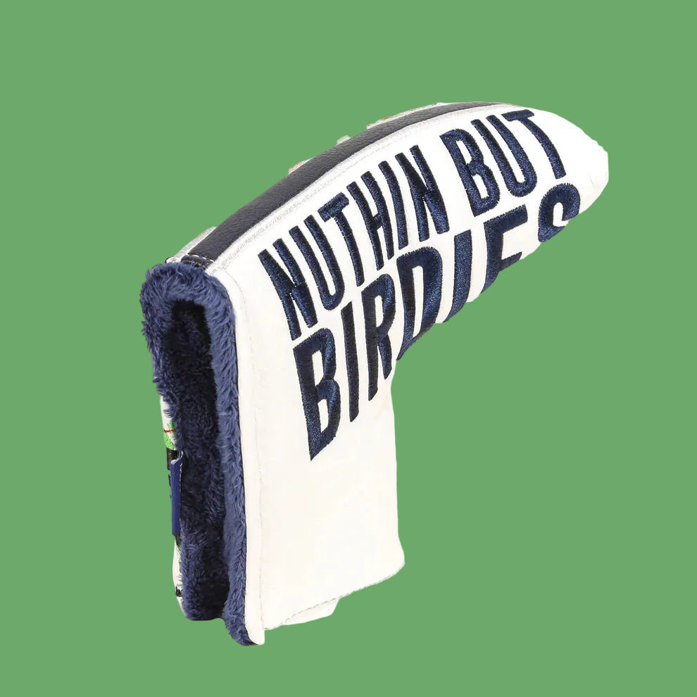 White and navy putter head cover with "Nuthin But Birdies" embroidered text and navy fuzzy interior lining, shown at angle against green background.