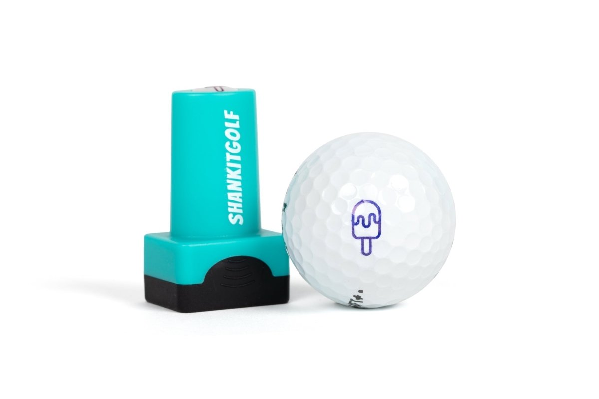 Turquoise ball stamper with "SHANKITGOLF" text and white golf ball printed with purple popsicle design, shown together on white background