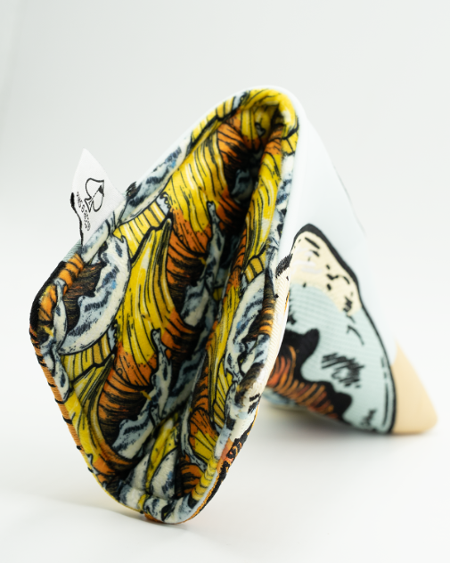 Putter blade cover featuring embroidered screwdriver cocktail design in yellow, orange, and black on white synthetic leather material, shown from angled side view