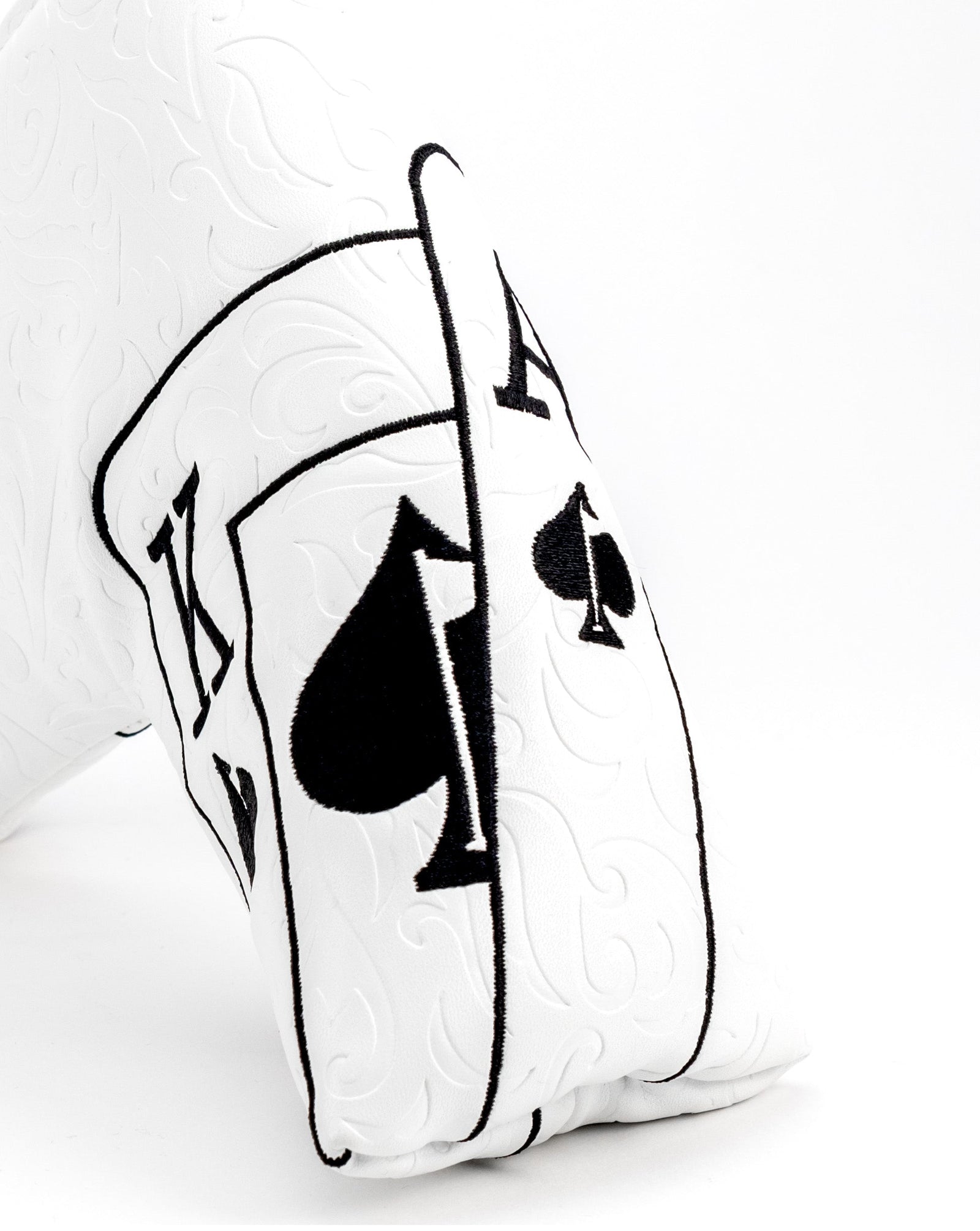 White putter blade cover with embroidered black Ace of Spades suit symbols and club outline design on faux leather material