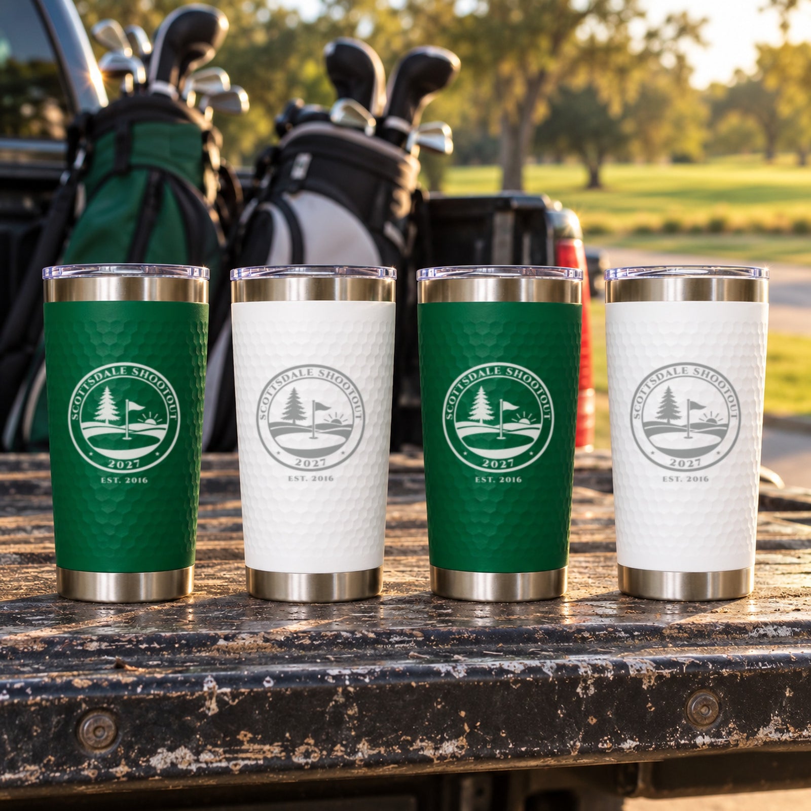 Four green and white golf trip tumblers engraved Scottsdale Shootout 2027 on a truck tailgate, golf trip gifts for the whole crew