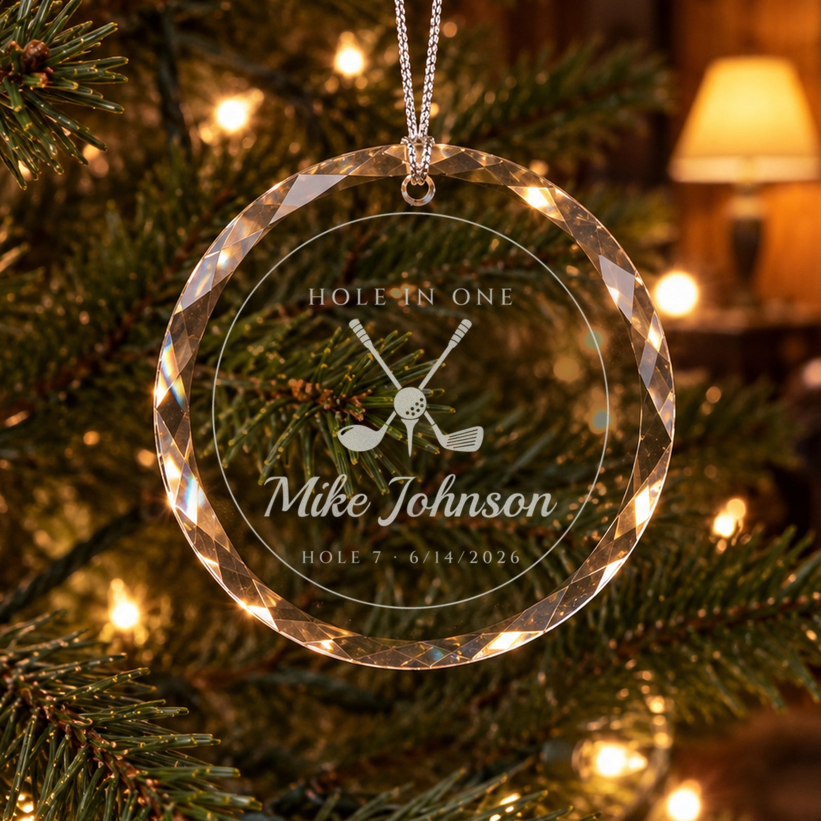 Personalized golf ornament in faceted glass on a lit Christmas tree, engraved with crossed golf clubs, HOLE IN ONE, Mike Johnson and HOLE 7, 6/14/2026