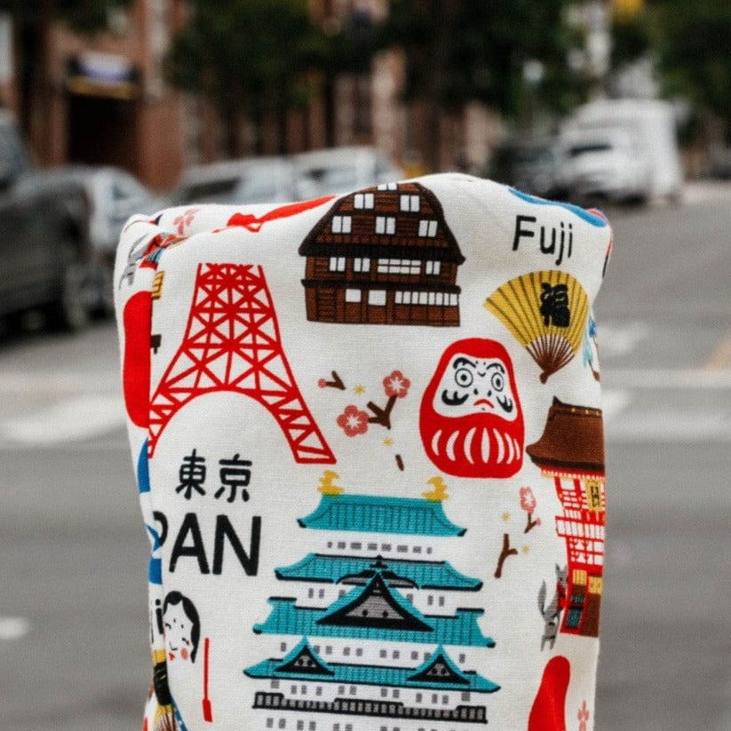 Tokyo-themed driver headcover with embroidered landmarks including Tokyo Tower, traditional temple, Mount Fuji text, daruma doll, and Japanese characters on cream cotton fabric