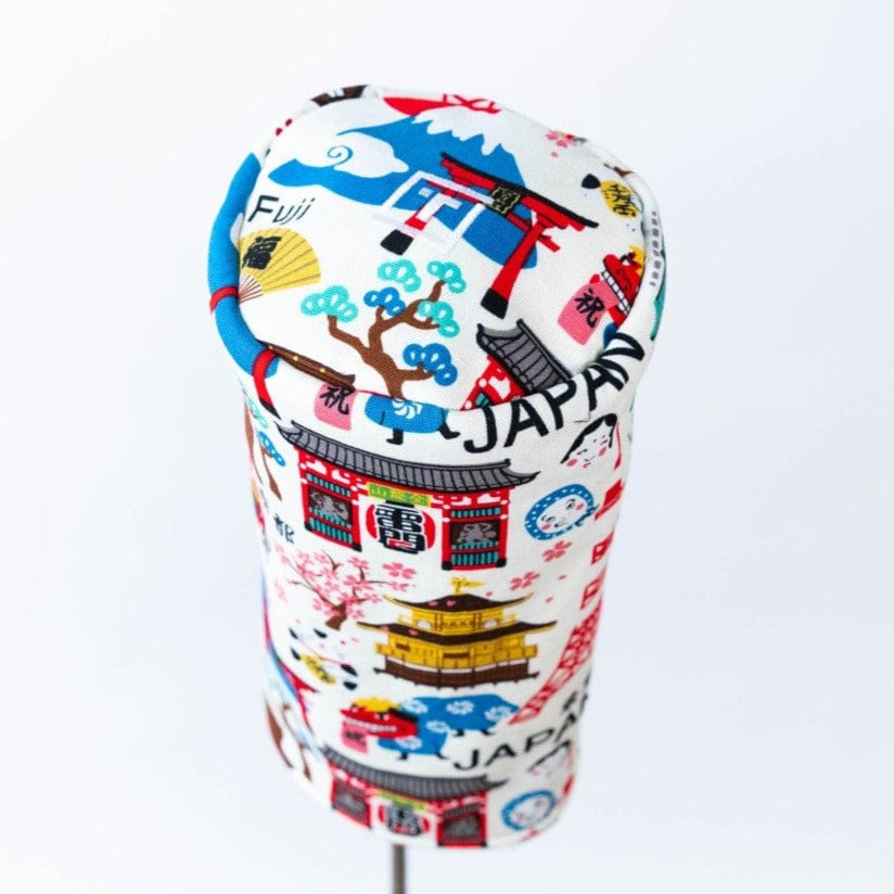 Handmade Tokyo-themed driver headcover featuring embroidered Japanese landmarks, Mount Fuji, pagodas, and text in blue, red, and gold on white fabric, shown from side angle