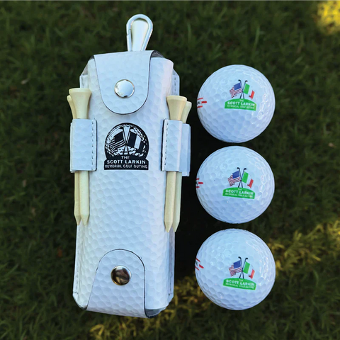 White golf gift set with personalized divot tool holder, two wooden tees, and three custom golf balls with example monogram on grass background.