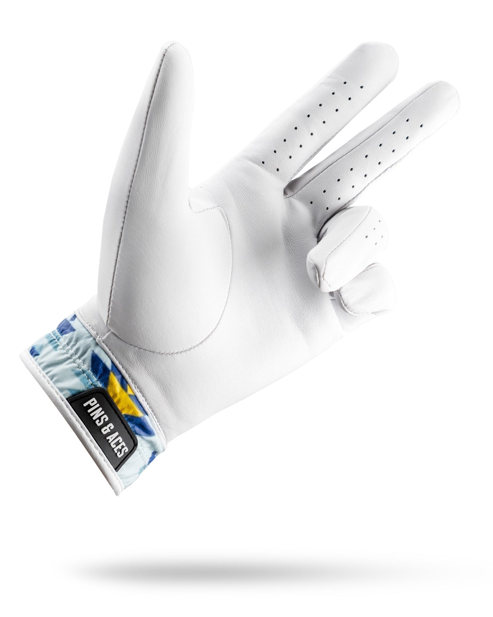 White leather golf glove with perforated fingers and Southwest-inspired geometric pattern on the wrist cuff in blue and yellow tones