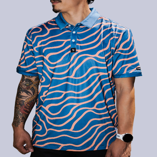 Men’s navy polo with peach wave-pattern print – dynamic, breathable, stretch-performance ready.
