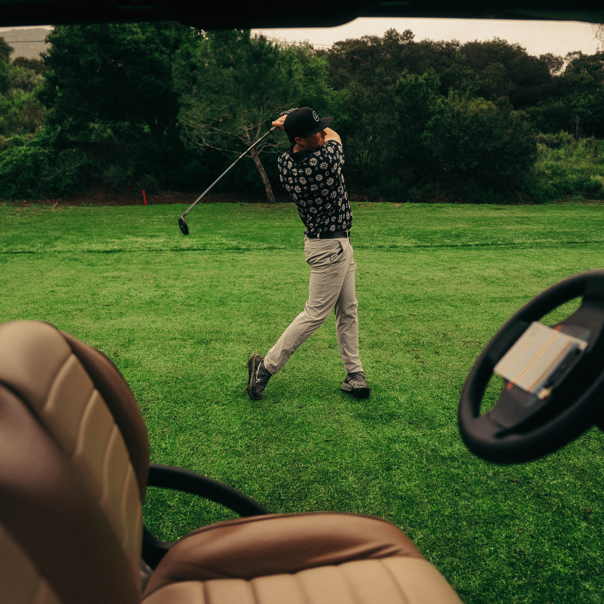 Men’s dark navy polo with white and grey daisy floral print – bold, breathable, stretch-performance ready.