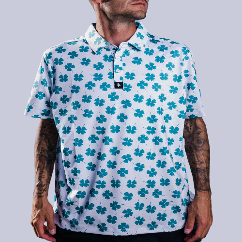 Men’s white polo with emerald-green four-leaf clover print – breathable, stretch-fit, and performance-ready.