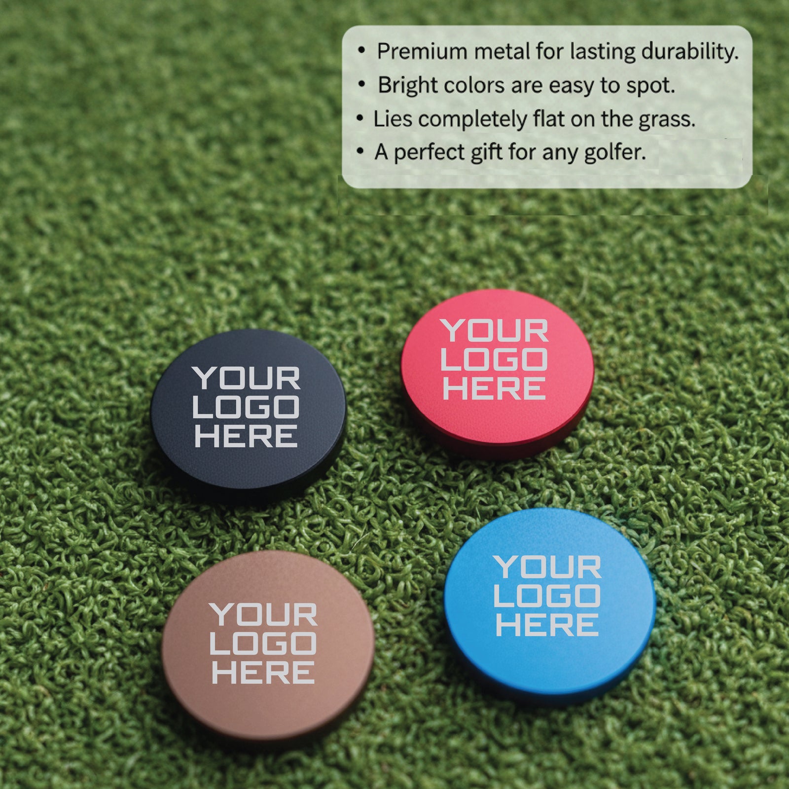 Four metal golf ball markers in navy, coral, tan, and blue with sample logo text displayed on artificial grass surface