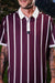 Men’s red and cream vertical stripe polo with crisp collar — varsity-inspired style with stretch, sun protection, and wrinkle resistance.