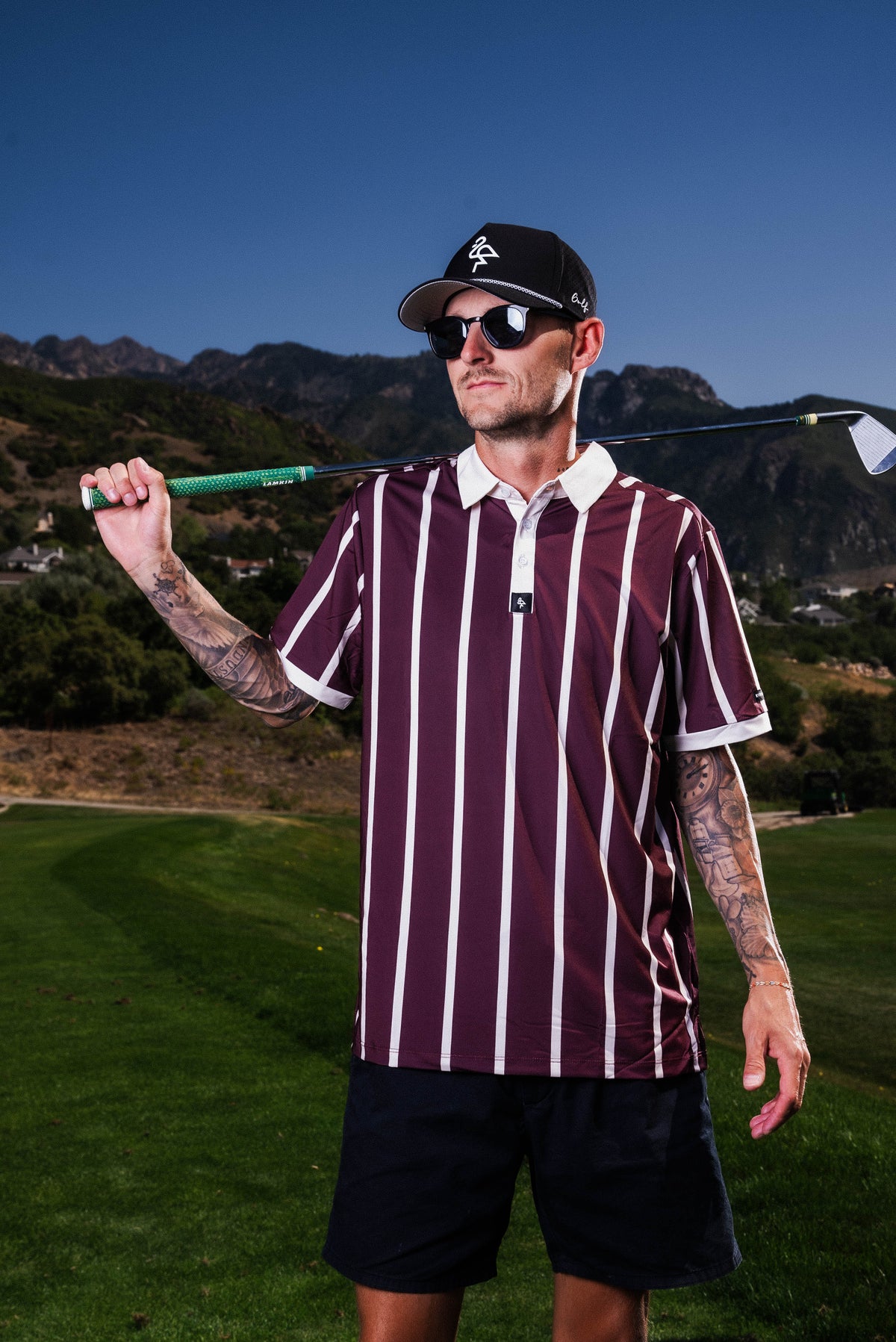 Men’s red and cream vertical stripe polo with crisp collar — varsity-inspired style with stretch, sun protection, and wrinkle resistance.