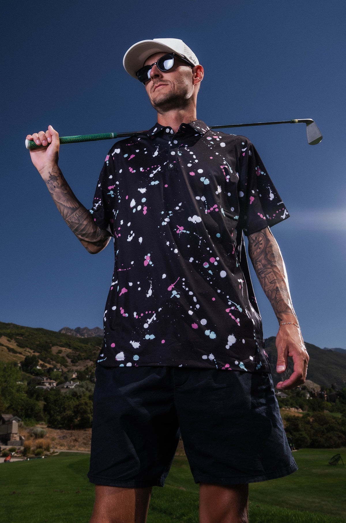 Men’s black polo with gray-white drip-speck pattern – urban-inspired, breathable, stretch-performance ready.