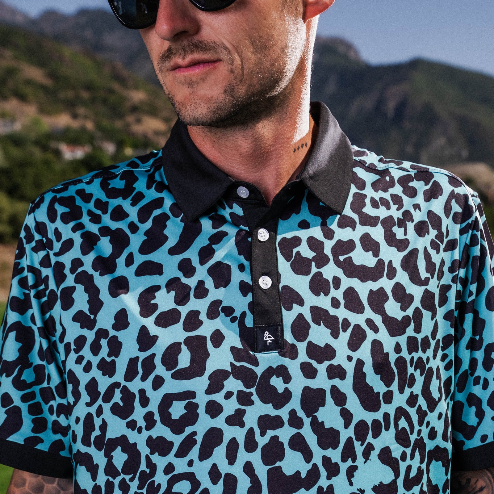 Men’s teal polo with tiger-stripe pattern – bold, breathable design with stretch, UPF 50+, and moisture-wicking performance.