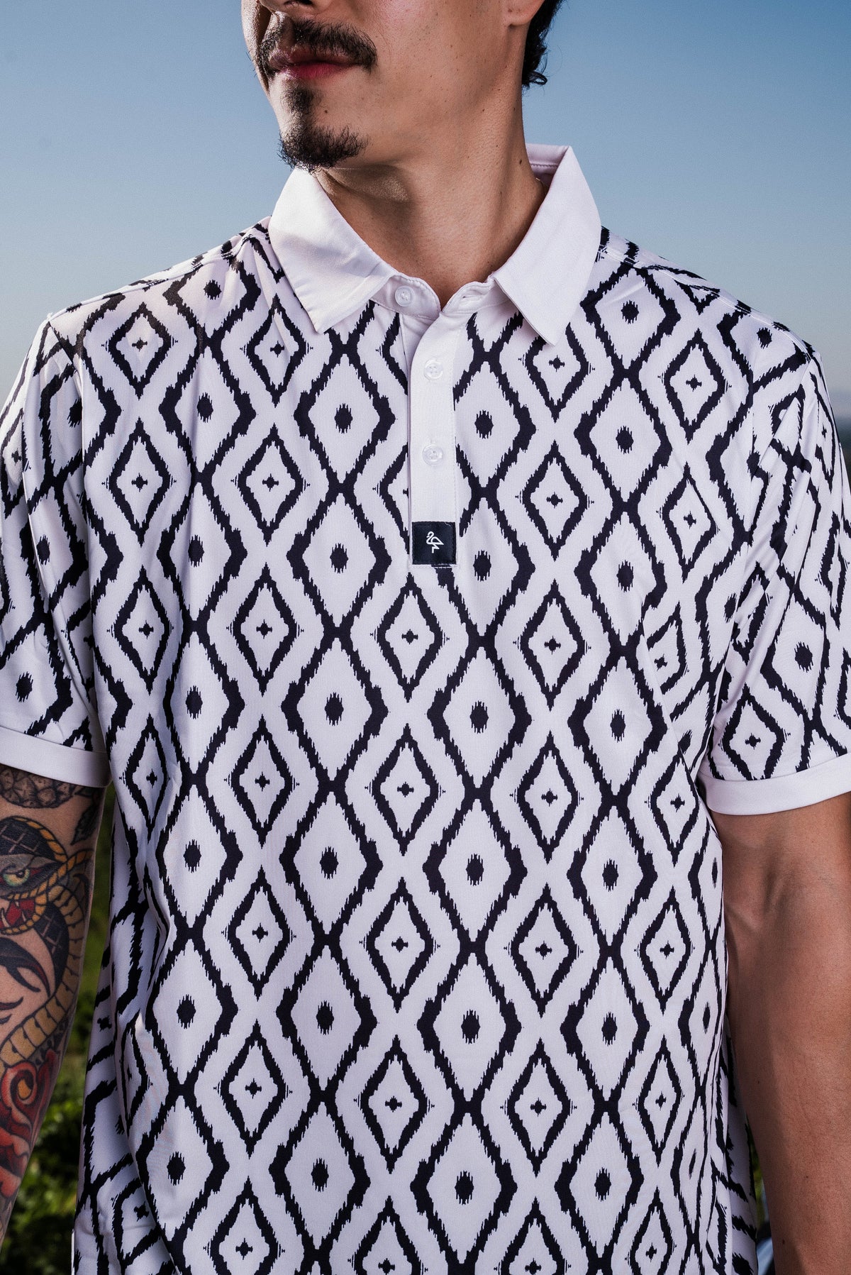 Men’s polo with blue neutral ikat geometric print – cultured, breathable, stretch-performance ready.