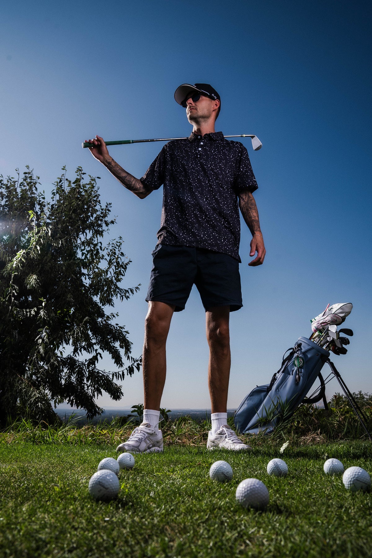 Men’s black polo with subtle gray-white speckle “cosmic sprinkle” print – sleek, breathable, stretch-performance ready.