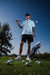 Men’s white polo with emerald-green four-leaf clover print – breathable, stretch-fit, and performance-ready.