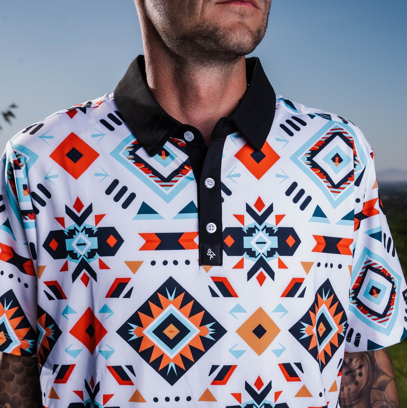 Men’s Aztec-print polo with tribal geometric motifs – vibrant, breathable, stretch-fit with performance features.