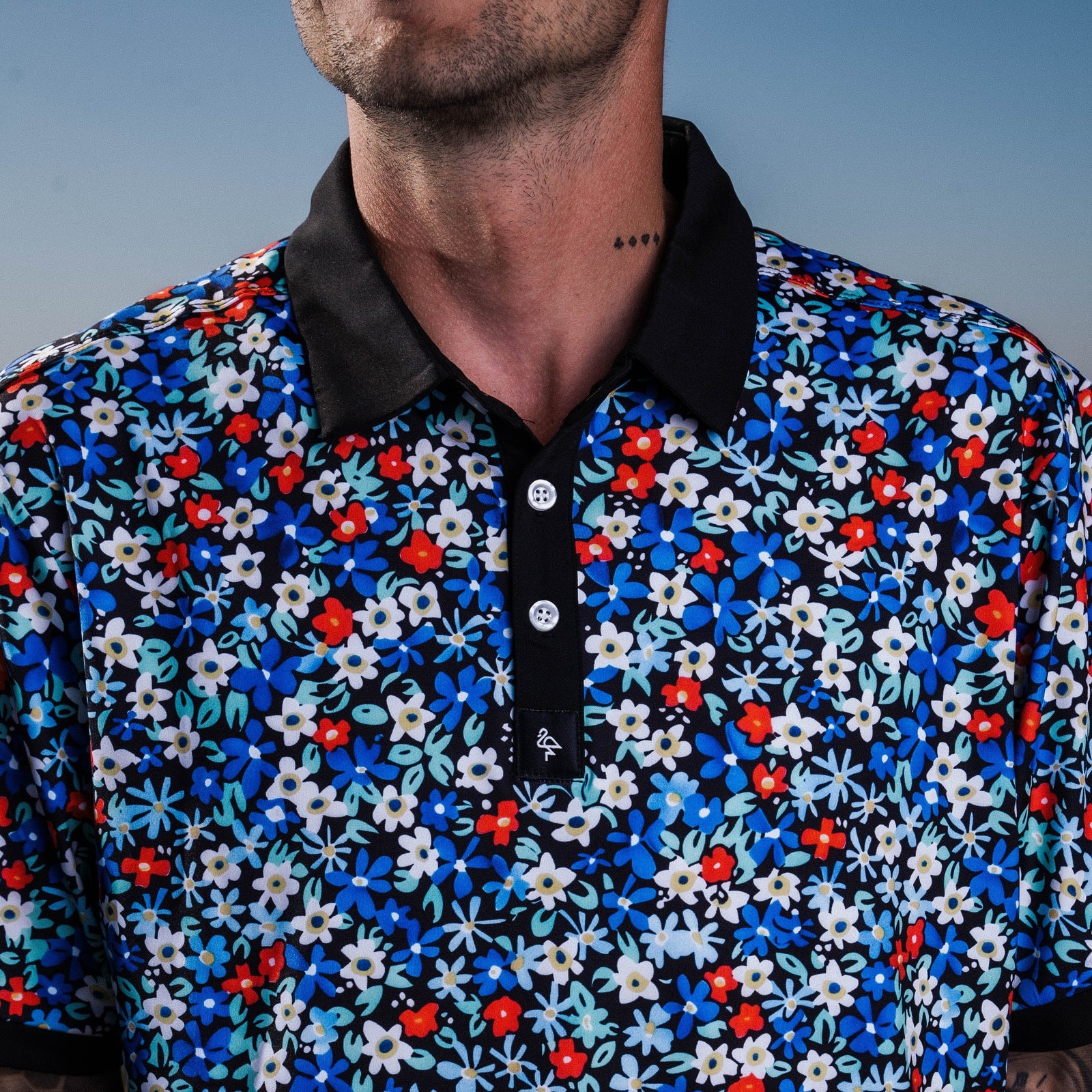 Men’s white polo with delicate pastel flower print – subtle floral detail, breathable, stretch-performance shirt.