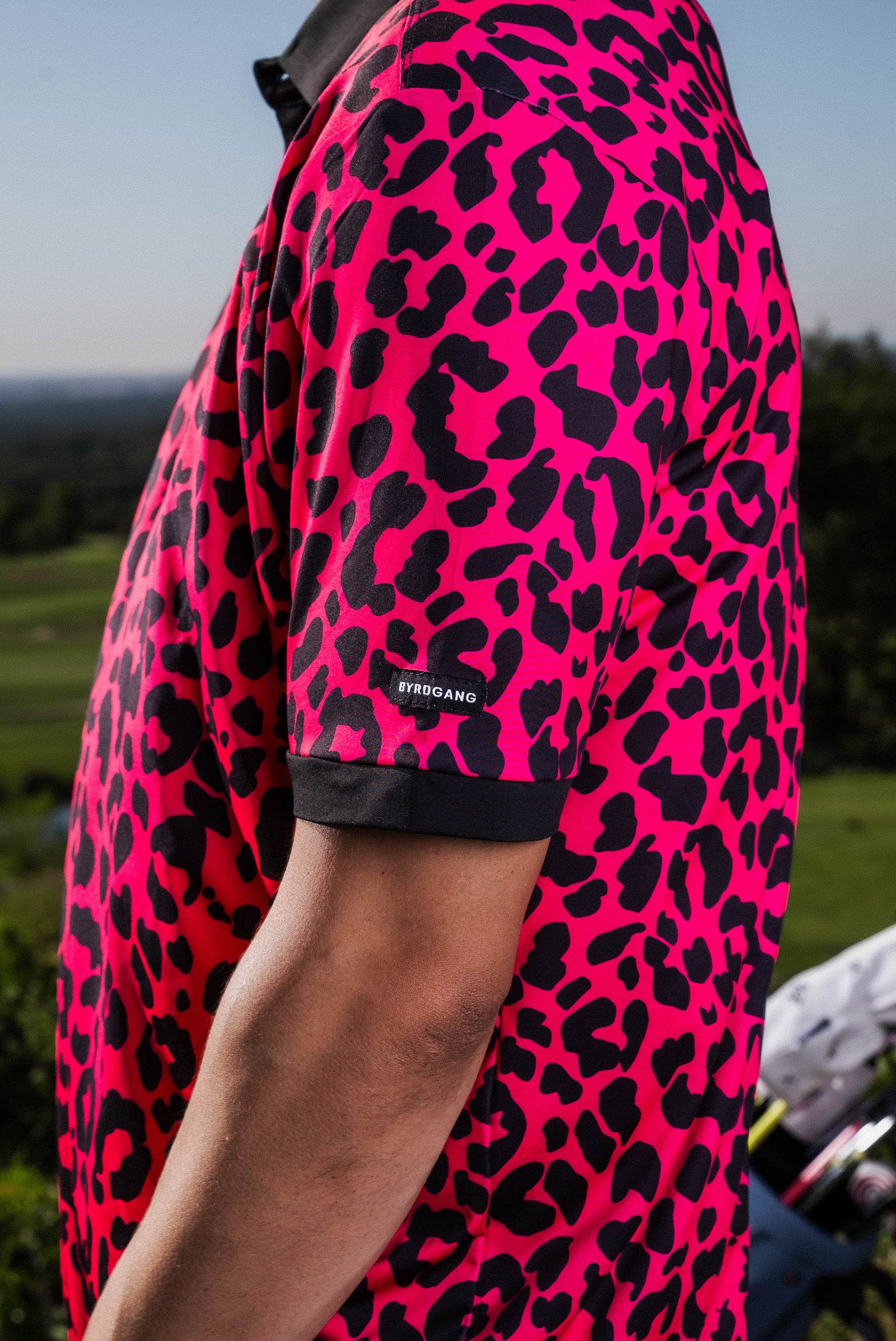 Men’s hot pink polo with black micro-spot pattern – bold, breathable, and stretch-fit performance.