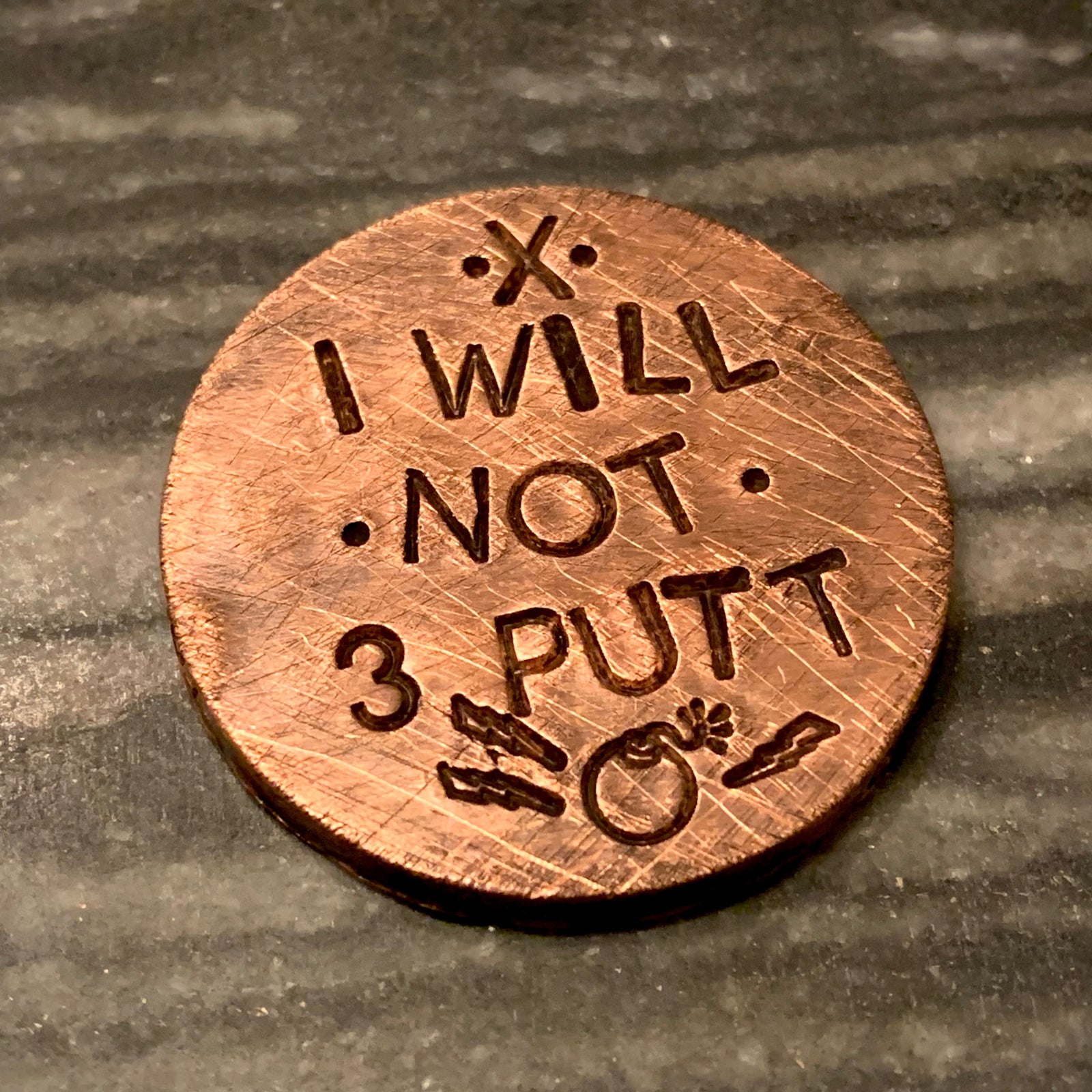 brass golf ball marker engraved “I WILL NOT 3 PUTT”