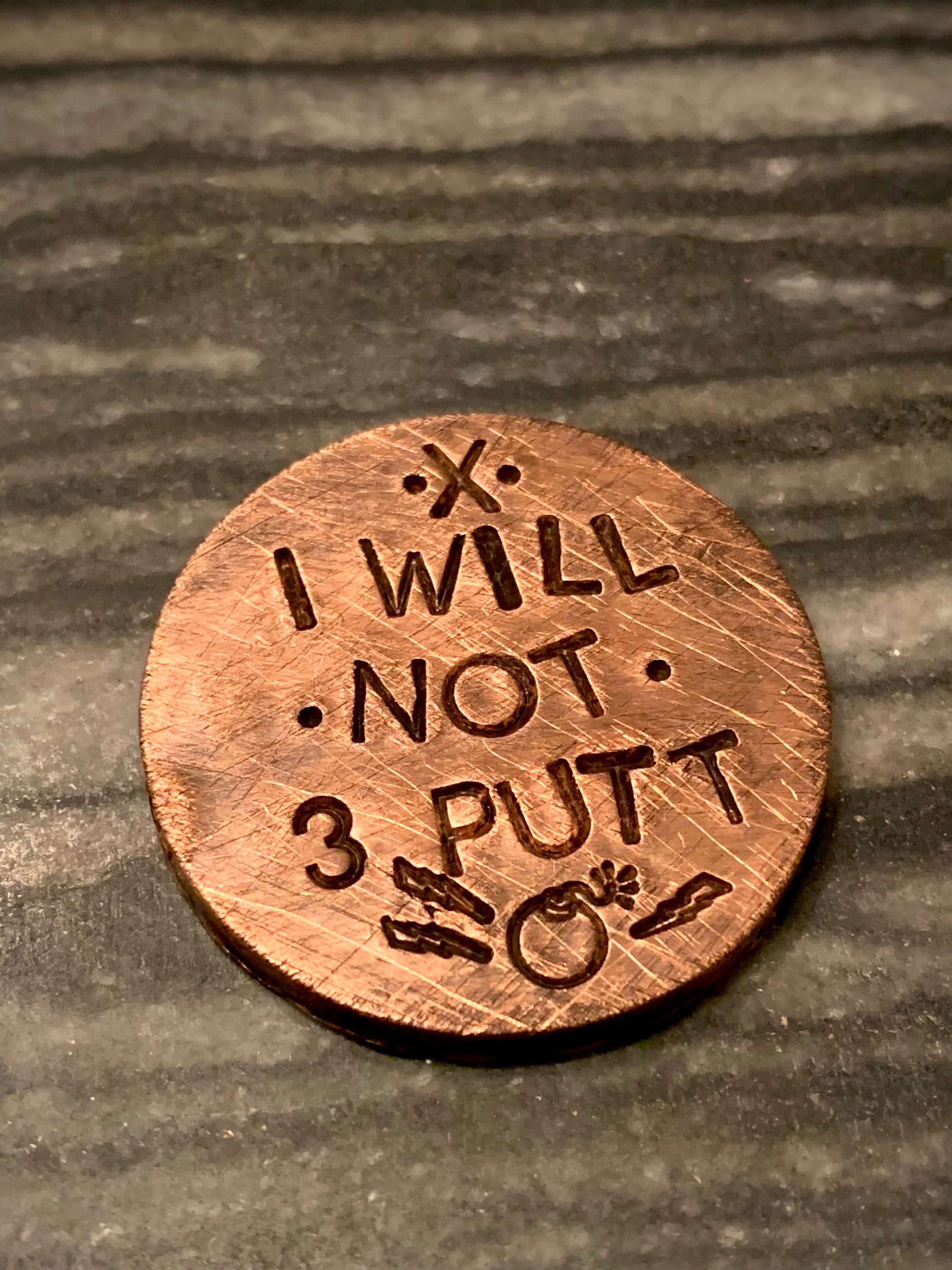 brass golf ball marker engraved “I WILL NOT 3 PUTT”