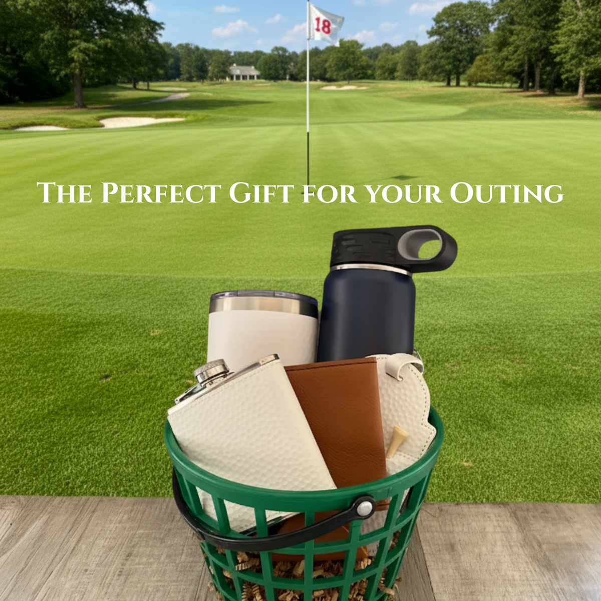Green range bucket filled with cream flask, brown leather bag tag, cream tumbler, black water bottle, and stainless divot tool, displayed on a golf course with flagstick in background