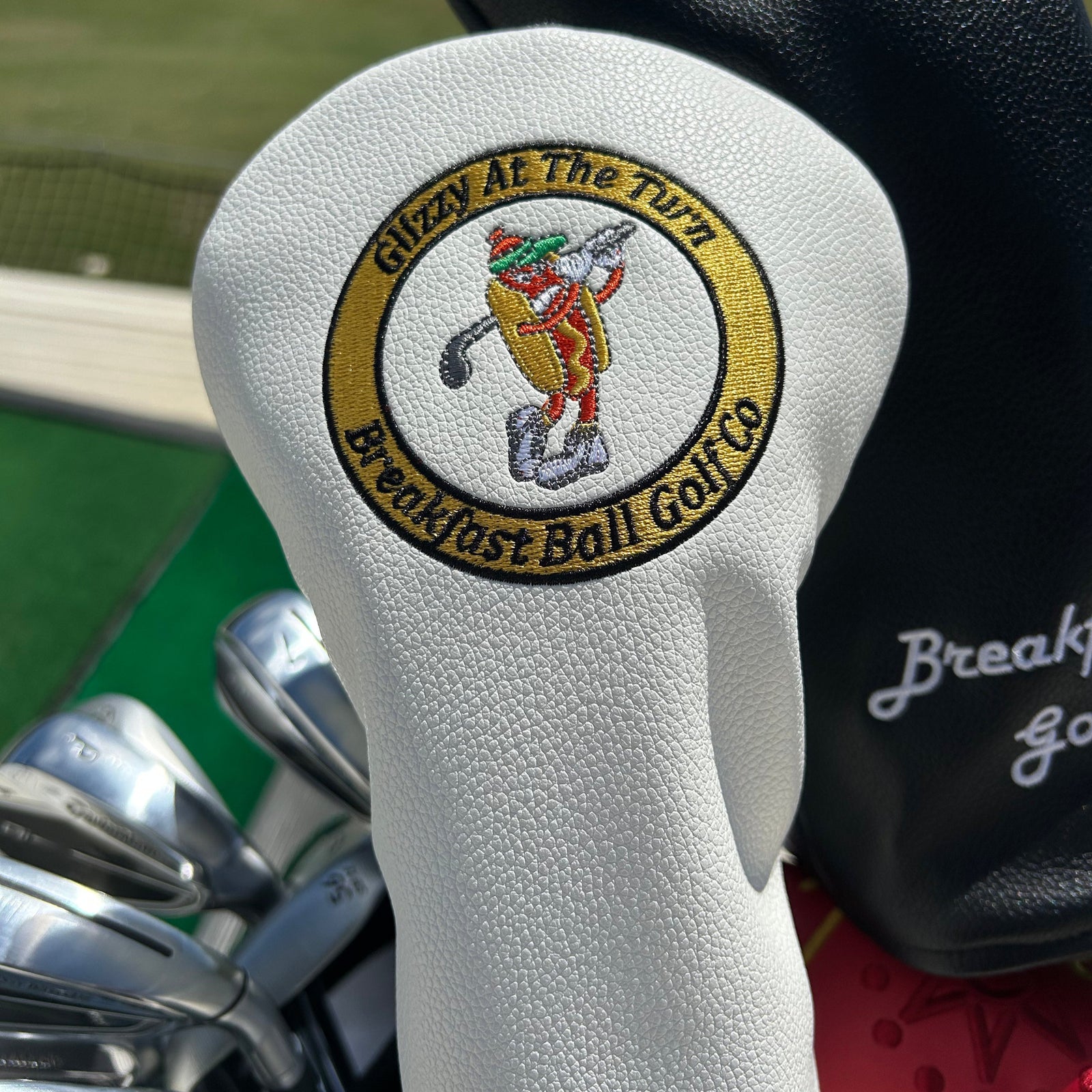White golf club head cover with a logo on a white background