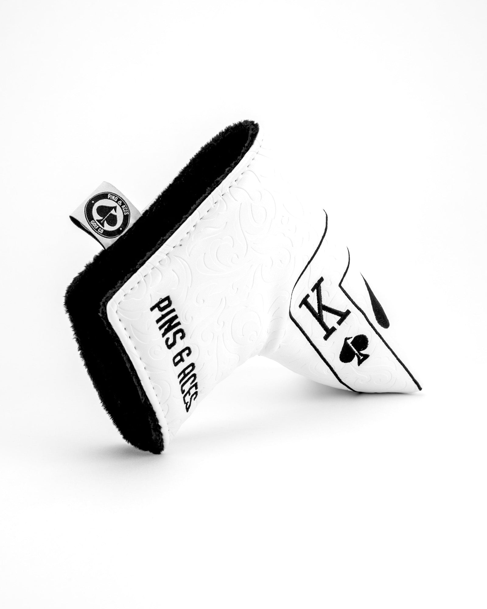 White putter blade cover with black fuzzy trim, embossed faux leather body, and embroidered Ace of Spades design on front flap