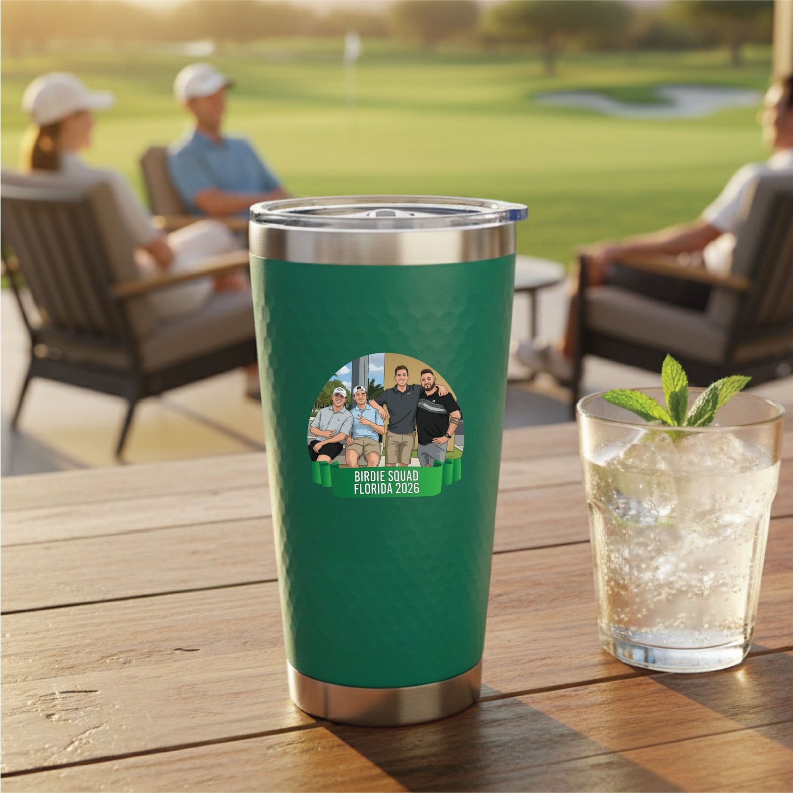 Green insulated tumbler with stainless steel rim displaying sample photo graphic labeled "Birdie Squad Florida 2026" on wooden table at golf course clubhouse