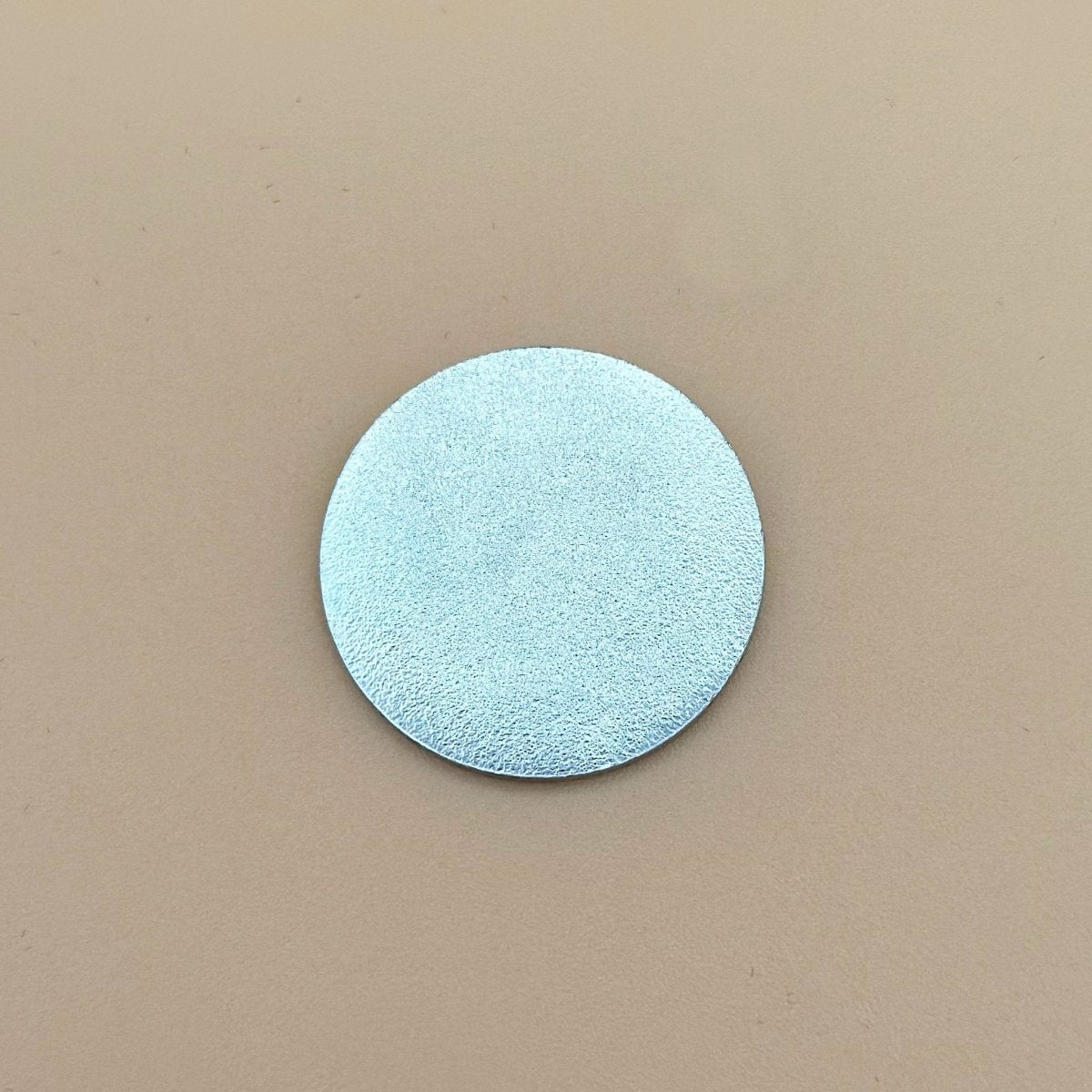 Light blue circular ball marker with textured surface and silver finish, shown against neutral background