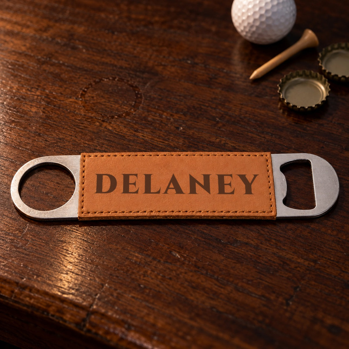 Engraved bar bottle opener from the golf beer mug gift set, the tan faux leather sleeve laser engraved with the name DELANEY