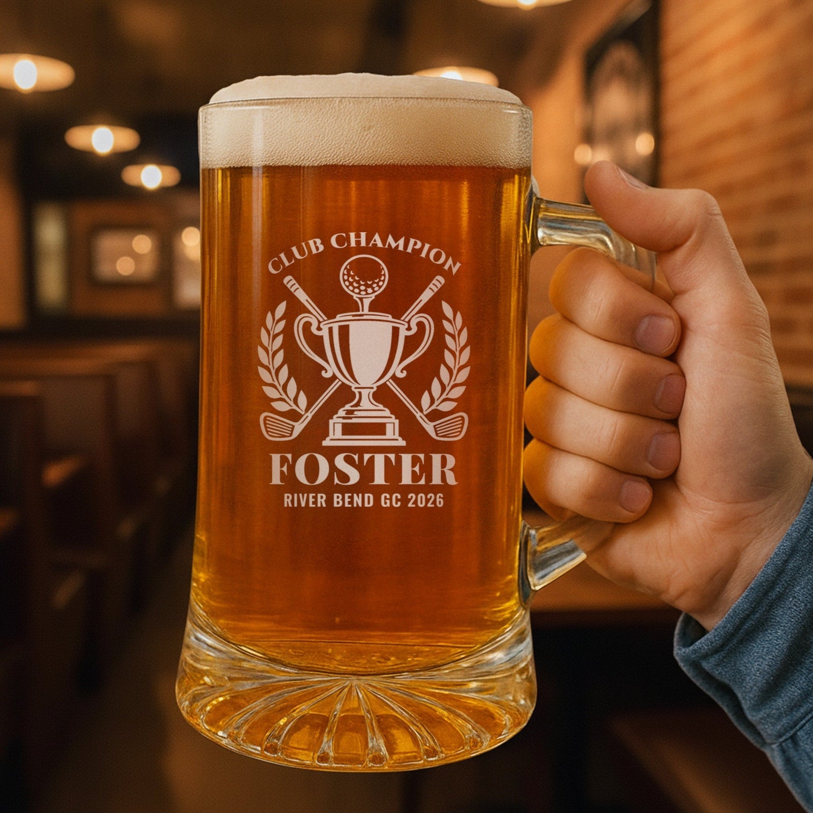 Hand holding the 25 oz golf club champion beer stein in a pub, engraved with the trophy and crossed clubs, Club Champion, Foster and River Bend GC 2026