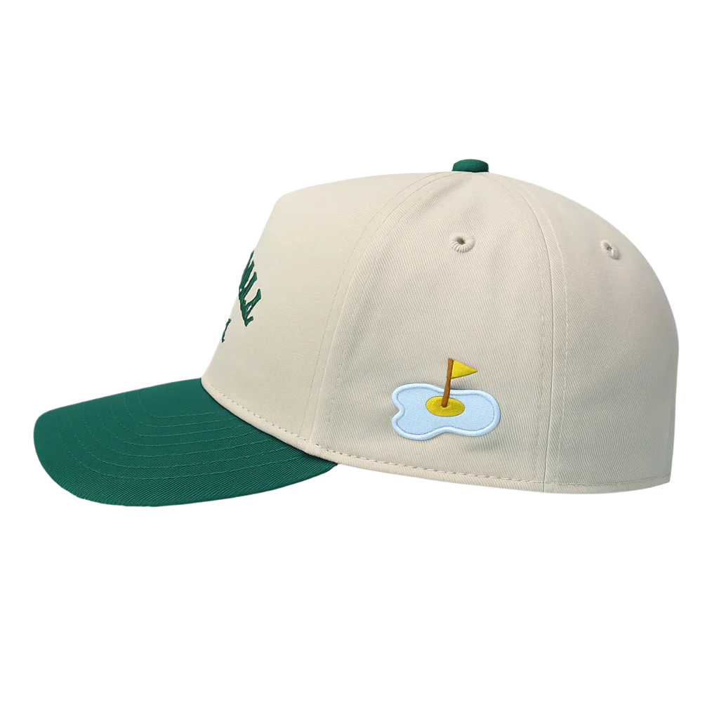 Beige and green cap with a golf-themed design on a white background