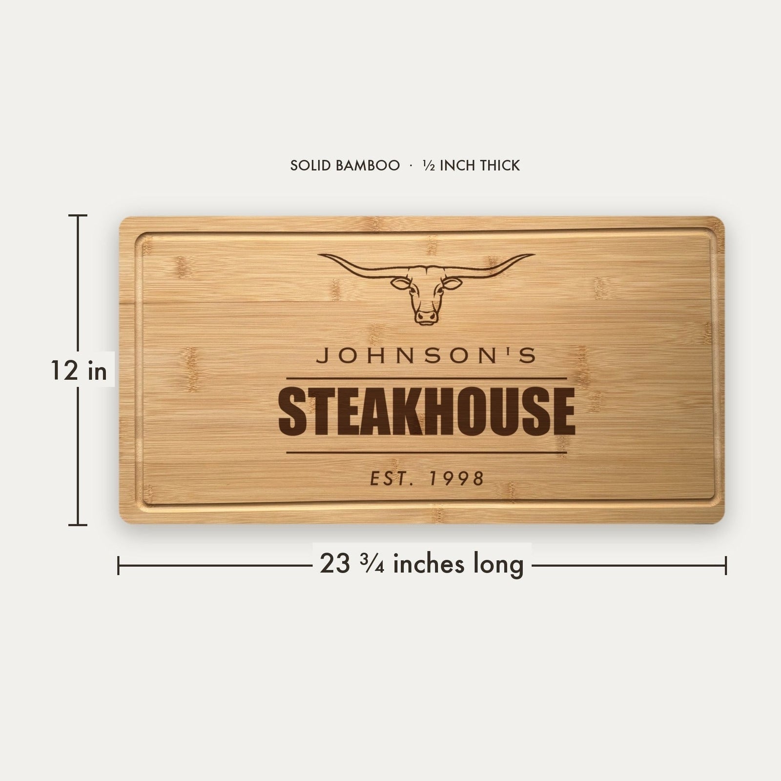 Size guide for the personalized steakhouse cutting board, 23 3/4 inches long by 12 inches wide in half inch thick solid bamboo with a carved drip ring
